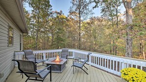 A wooden deck with outdoor furniture, a fire pit, and a white railing. - Fire Pit & Grill: Tranquil Retreat in Hot Springs (Hot Springs Village)
