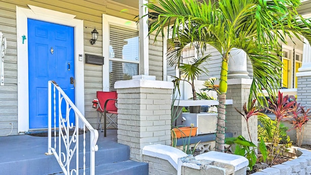A blue door, a red chair, and a palm tree in front of a building. - Walk to Parks & Dining! Updated Ybor City Home (Tampa)