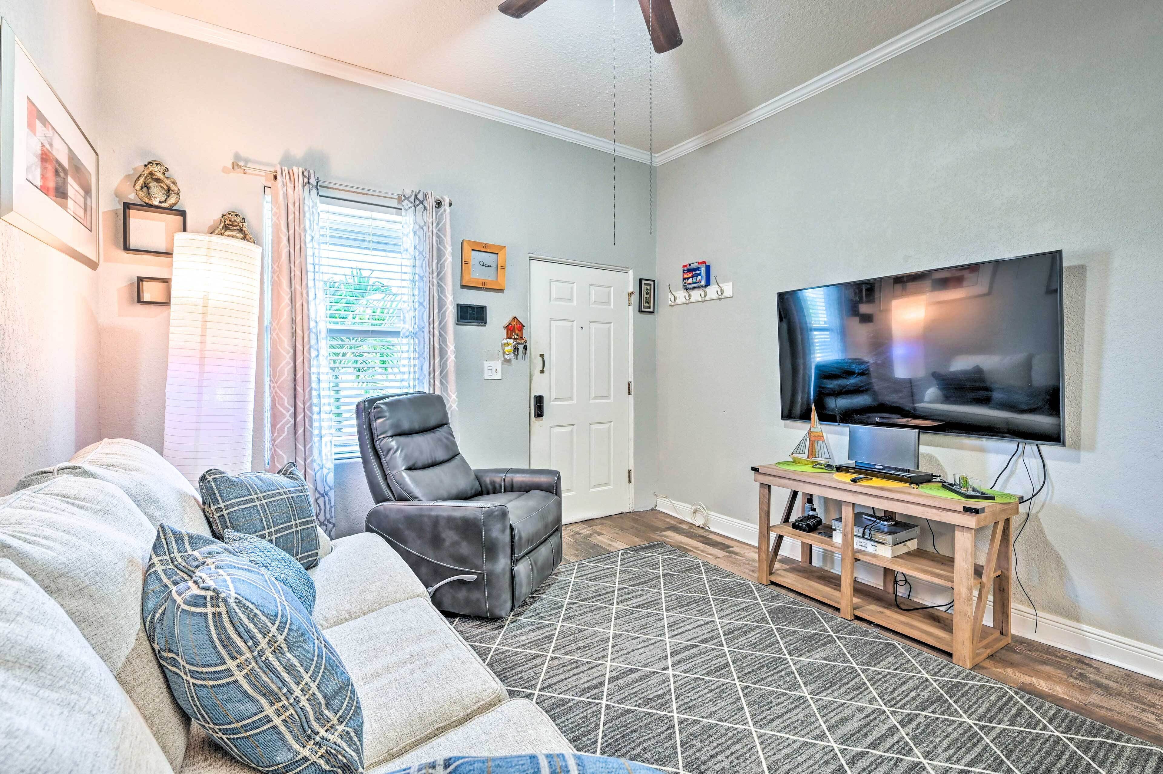 Una sala de estar con un sofá, un sillón reclinable, un televisor y una mesa de centro de madera.