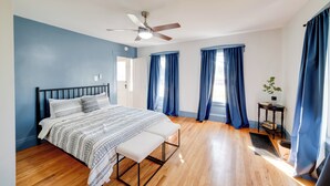 A bedroom with a bed, a bench, a ceiling fan, and a small table with a plant. - < 4 Mi to Cooperstown: Charming Historic Home! (Fly Creek)