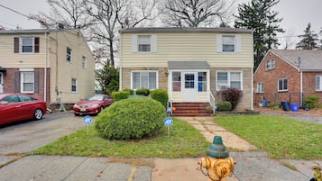 Stunning home with a yard and driveway, featuring a brick foundation and a lush lawn.