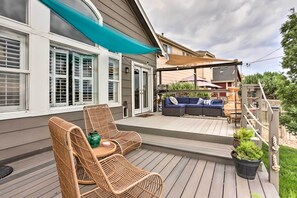 A covered outdoor deck with wicker furniture, a sofa, and potted plants. - Scenic Home w/ Furnished Deck ~ 14 Mi to Denver (Henderson)