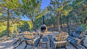 Un espace extérieur aménagé avec des chaises Adirondack et un poêle à bois.