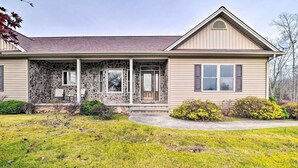 A single-story house with a stone facade, a front porch, and a well-maintained lawn. - King Suite Haven Near Dale Hollow Lake & Boat Slip (Burkesville)