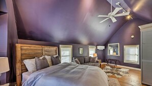 Ein Schlafzimmer mit einem großen Bett, einem Deckenventilator und einem hölzernen Kopfteil.