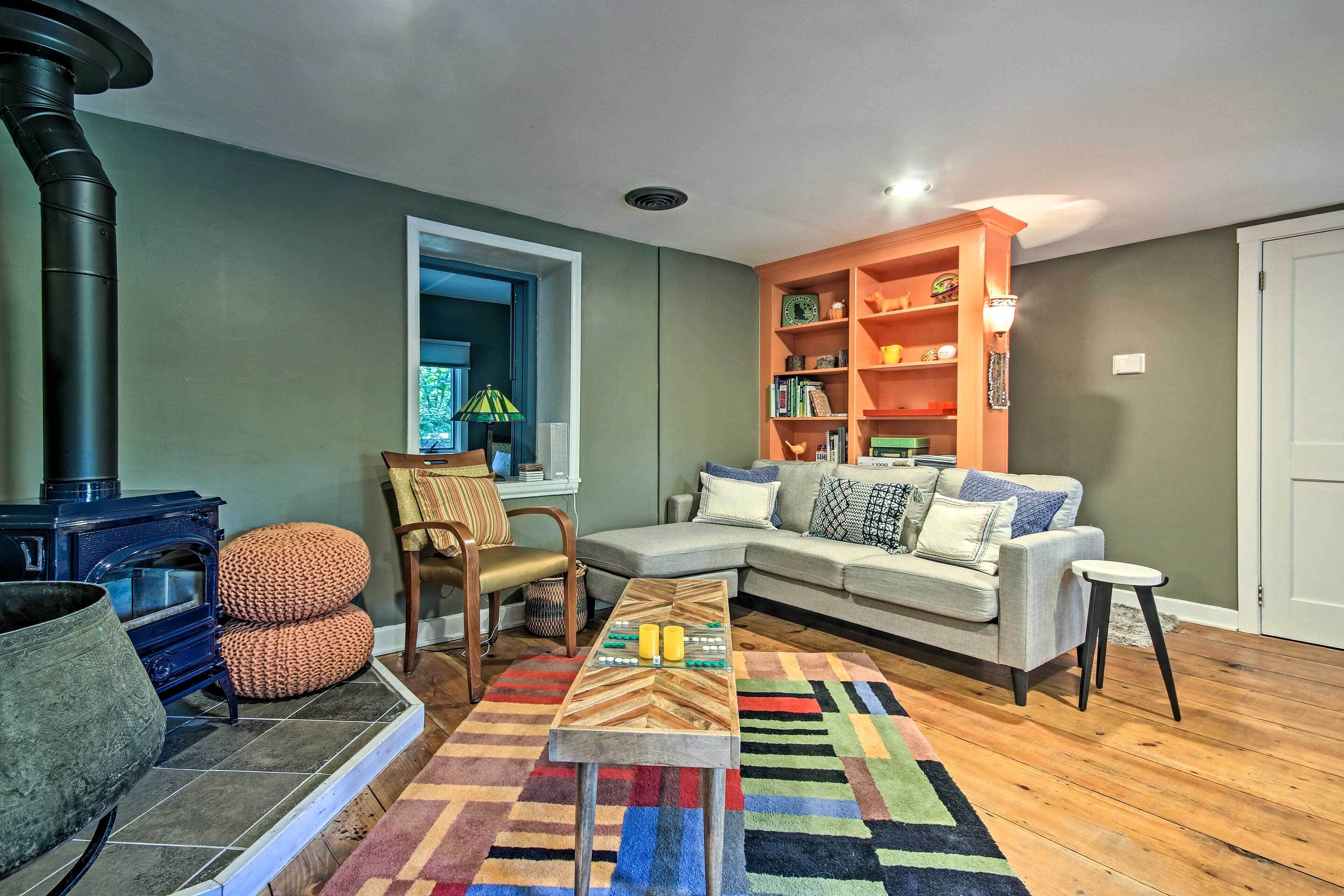 A cozy living room with a fireplace, a sofa, a coffee table, and a bookshelf.