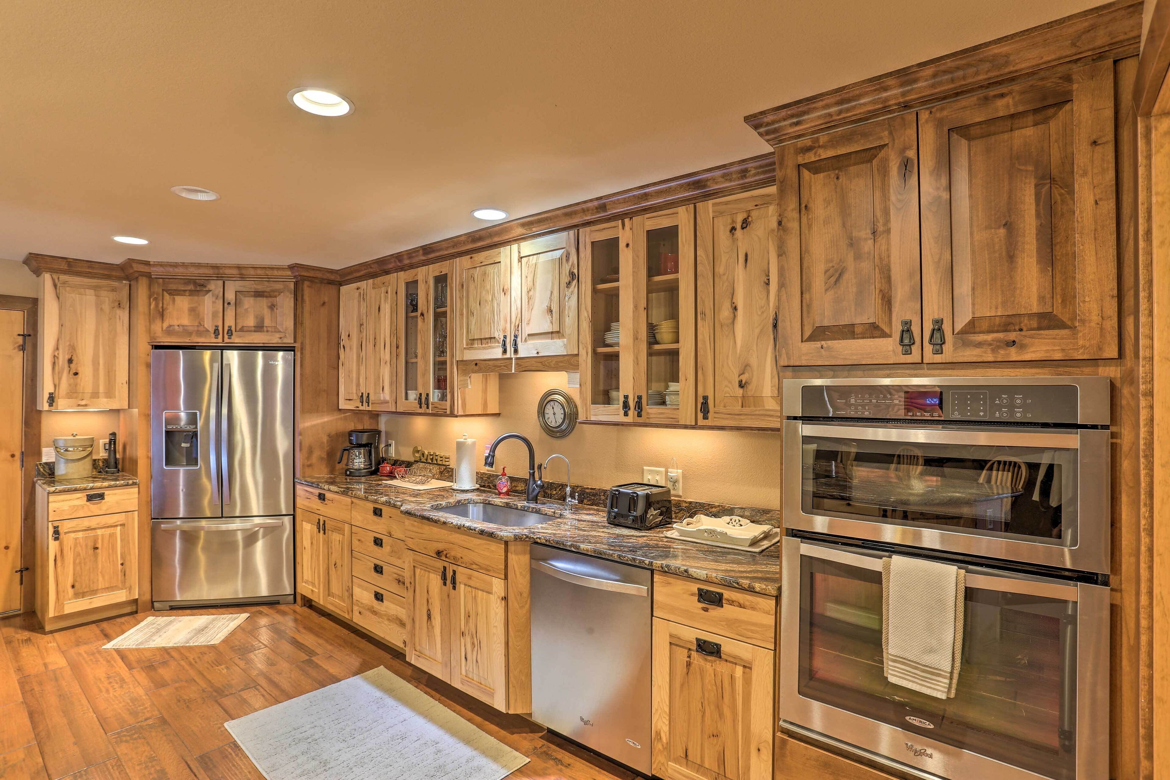 A kitchen with wooden cabinets, stainless steel appliances, and a granite countertop.