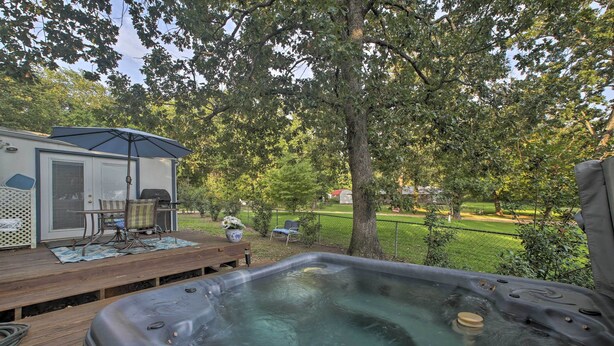 A hot tub on a wooden deck with a covered seating area and a camper in the background. - Hot Tub & Deck: Tranquil Home Near Grand Lake (Grove)
