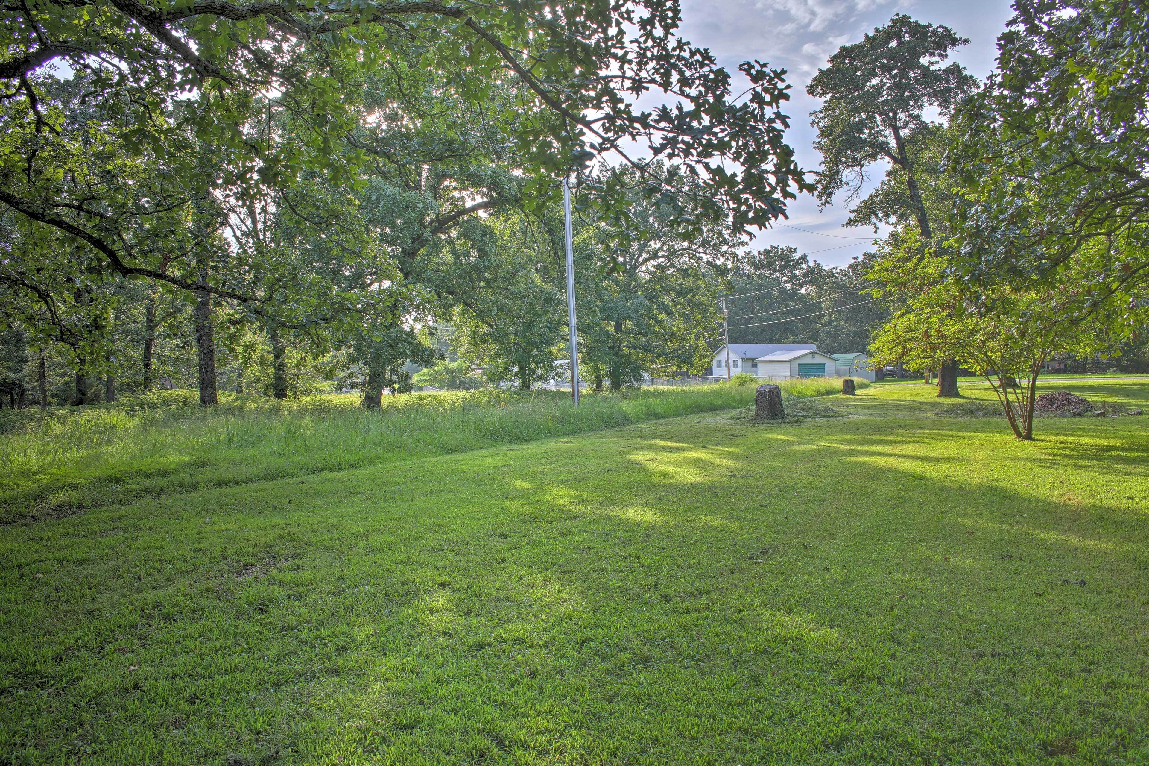 A grassy area with trees and a building in the background.