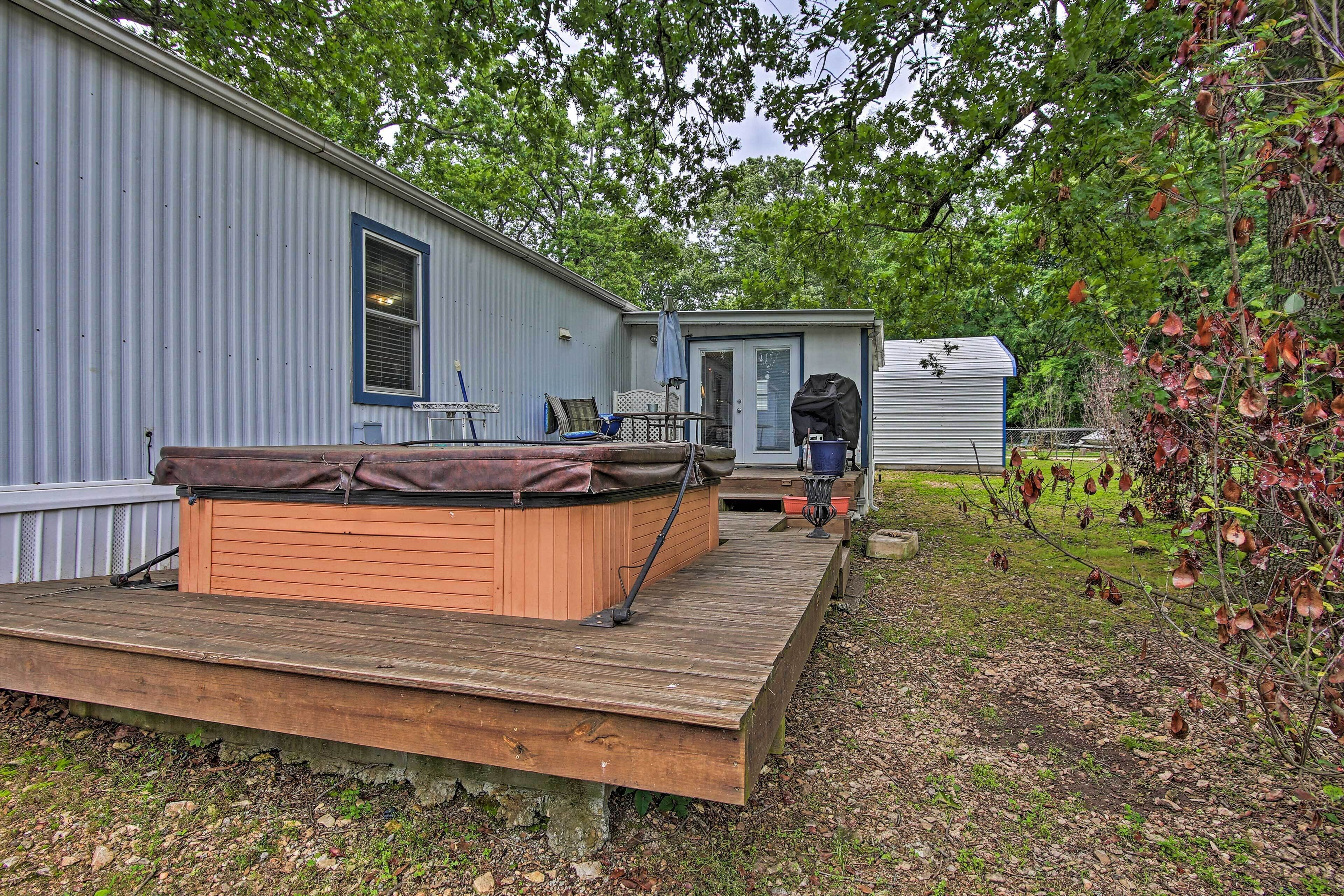Ein Bungalow mit Terrasse, Whirlpool und überdachter Sitzgruppe.