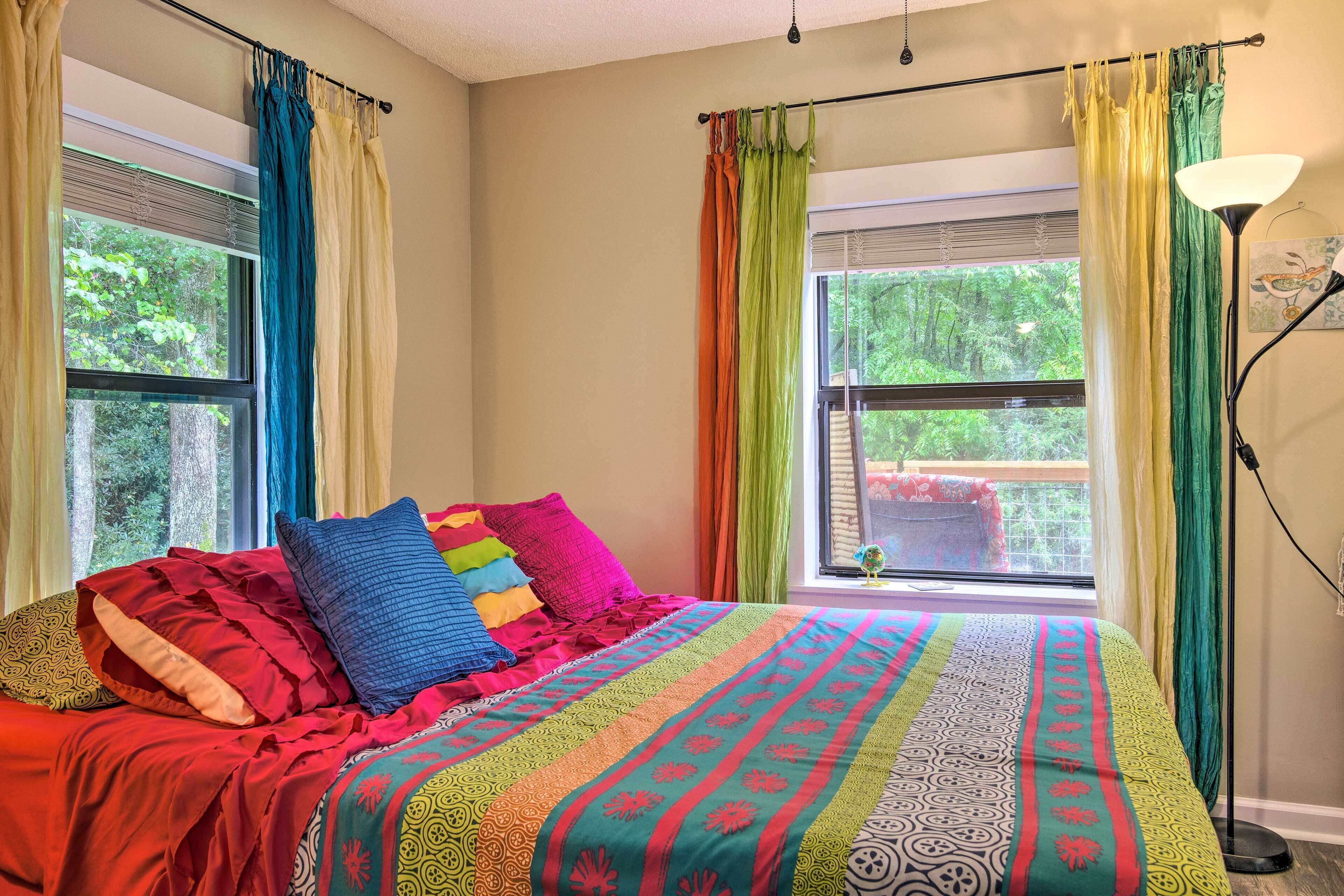 Una camera da letto con un letto grande, biancheria colorata e tende.