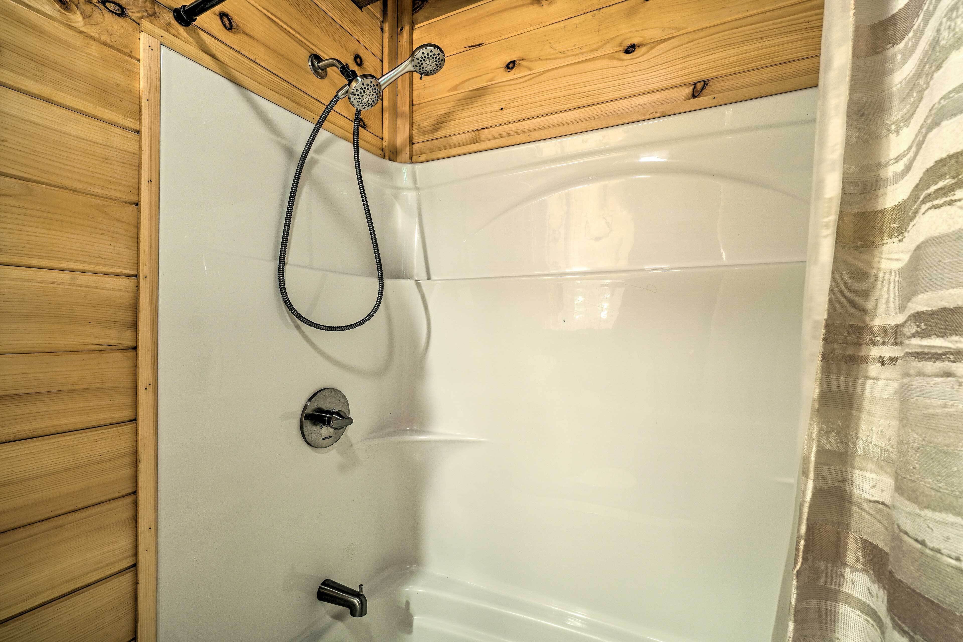 Un box de ducha con paneles de madera, pared de azulejos blancos y ducha.