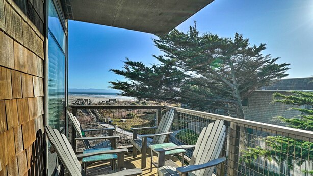 A balcony with Adirondack chairs, a view of the beach, and a large tree. - Beachfront Pajaro Dunes Condo w/ Bay Views! (Watsonville)