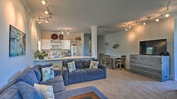 Una sala de estar moderna con un sofá modular, una mesa de centro y un televisor.
