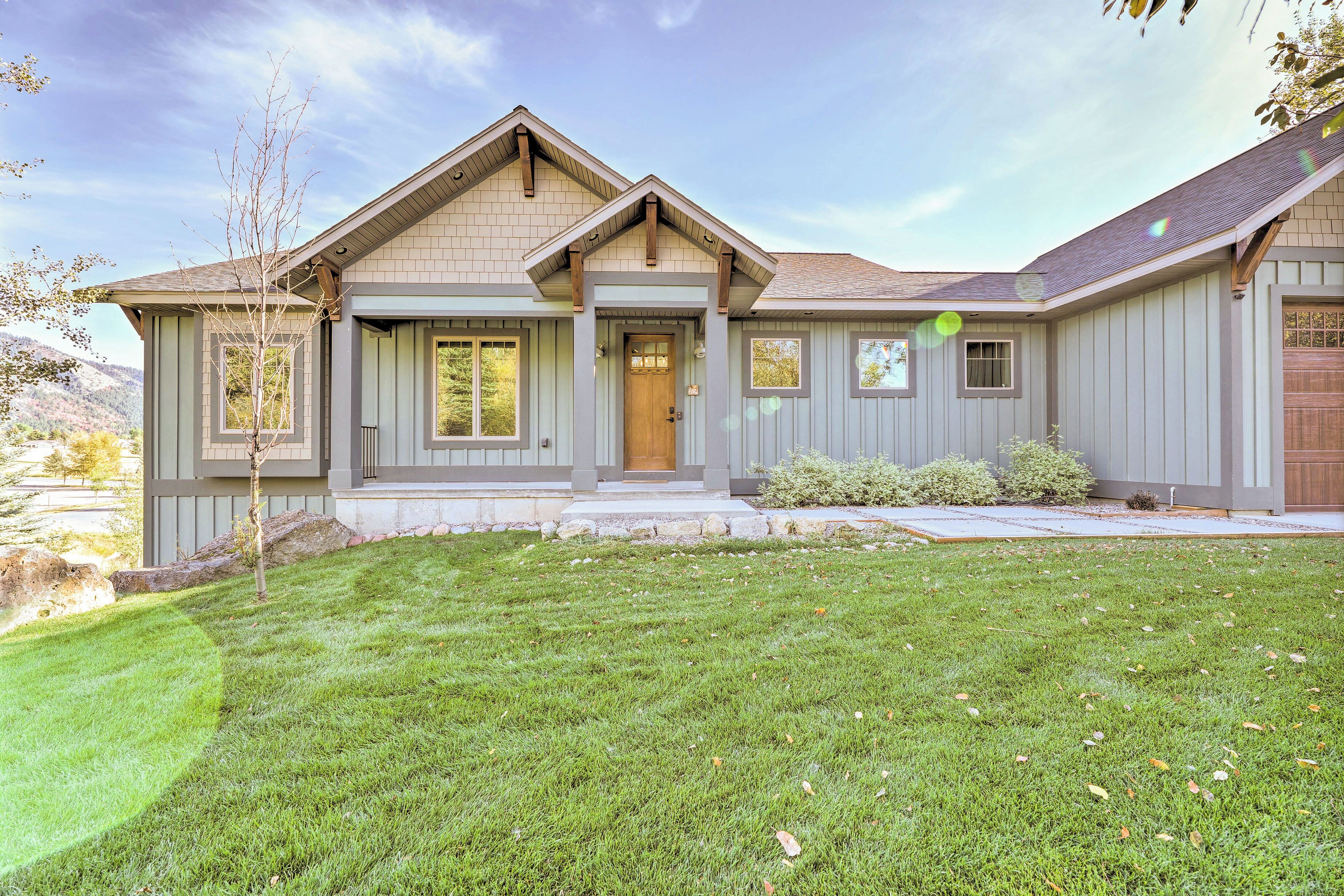 A two-story house with a front porch, a garage, and a well-maintained lawn.
