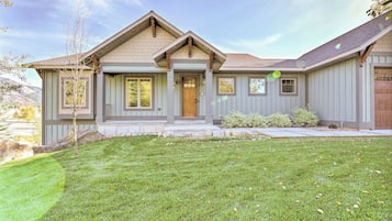 A two-story house with a front porch, a garage, and a well-maintained lawn.