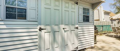A garage with two white doors, a window, and a small attached shed.