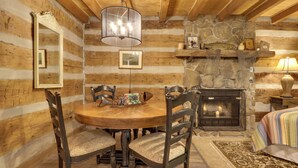A rustic wooden interior with a stone fireplace, wooden dining table, and chairs. - 3 Mi to Natl Park: Townsend Apt on Little River! (Townsend)