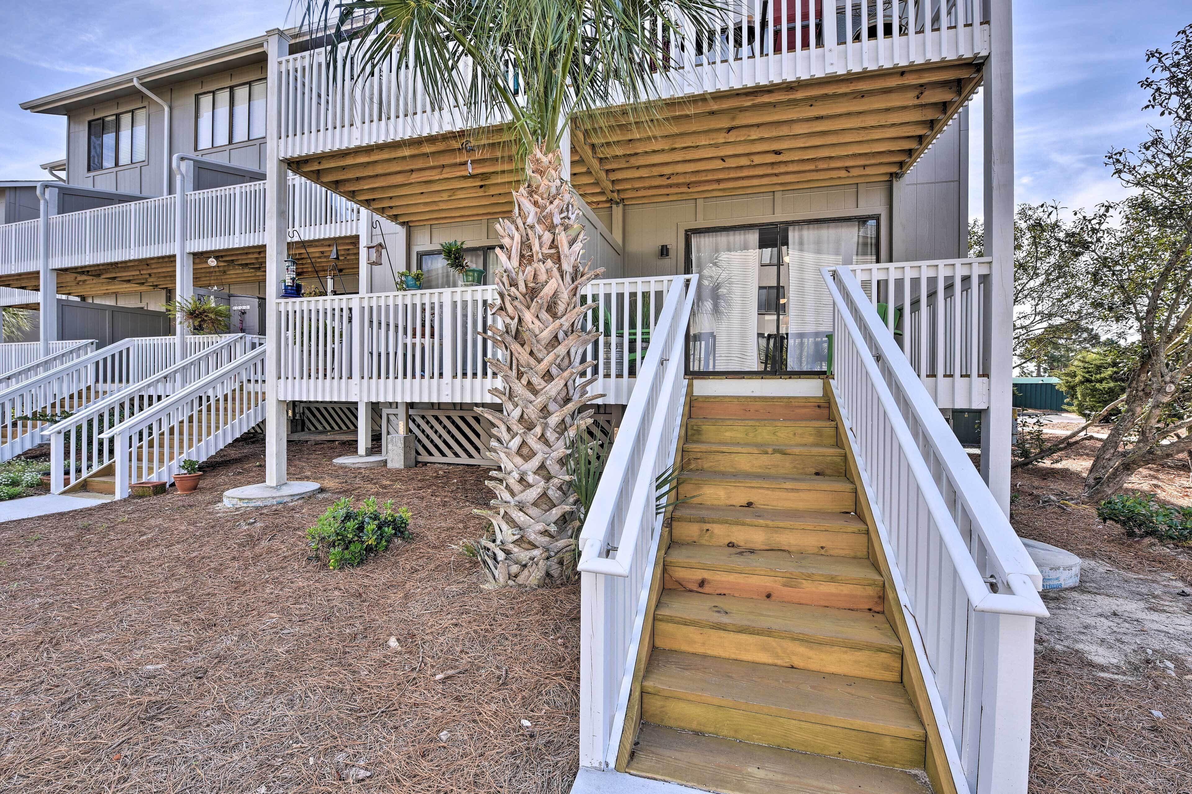 A multi-story building with white railings and wooden balconies.