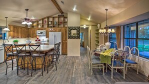 Una cocina amplia con armarios de madera, una isla central con taburetes de bar y un comedor con mesa y sillas.