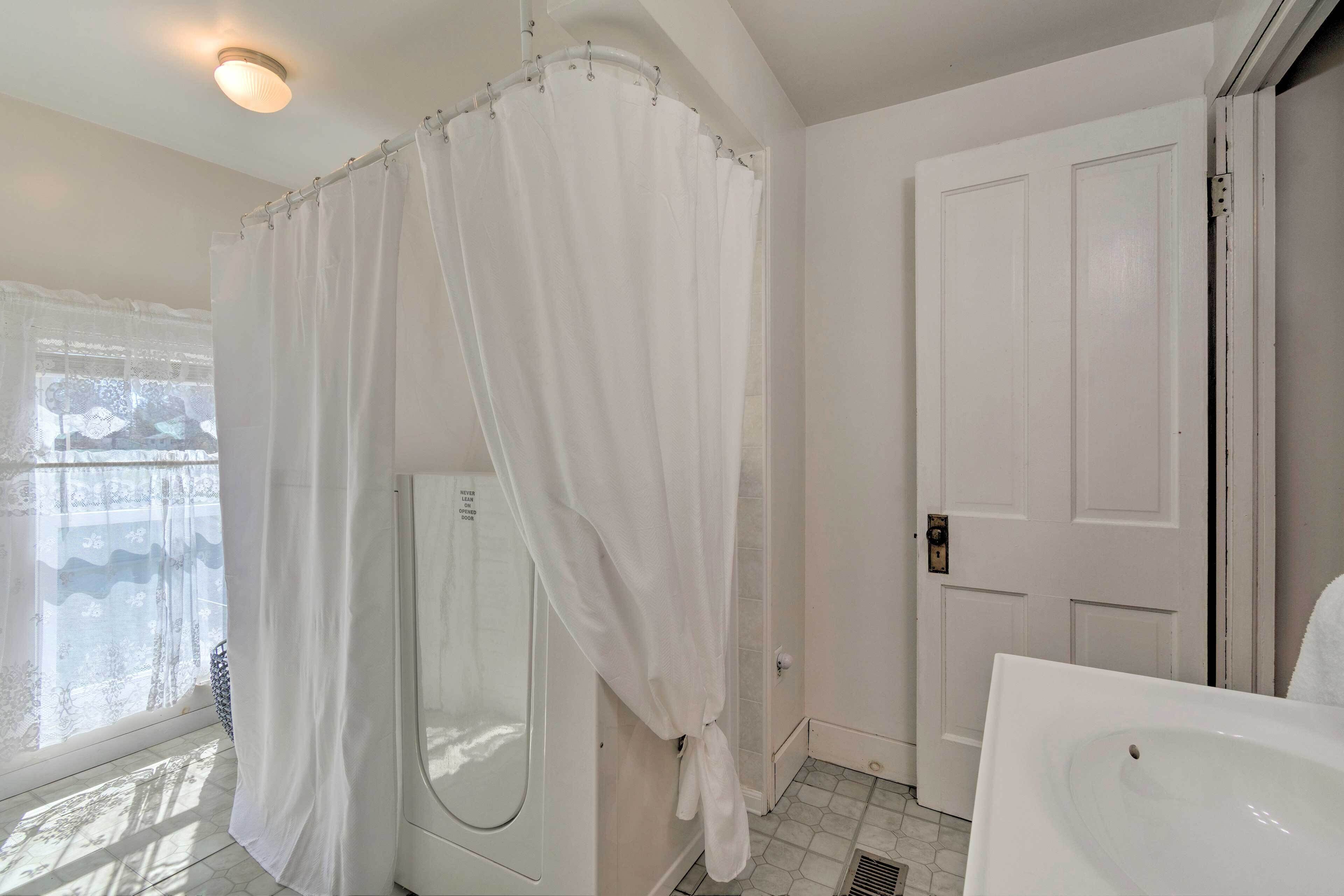 A bathroom with a shower, a toilet, and a sink.