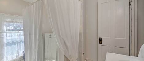 A bathroom with a shower, a toilet, and a sink.