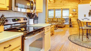 Une cuisine équipée d’appareils électroménagers modernes, dotée de meubles en bois et comprenant un coin repas avec une table et des chaises.