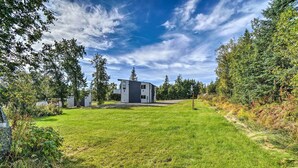 Ein modernes Haus mit gepflegtem Rasen, umgeben von Bäumen und blauem Himmel.