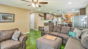 A modern living room with a sectional sofa, a coffee table, and a ceiling fan. - Brand New Cotter Home, Walk to Trout Fishing! (Cotter)