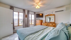 A bedroom with a bed, a dresser, a television, and a ceiling fan. - Alpine Lake Resort Home: Stunning Lake Views! (Terra Alta)