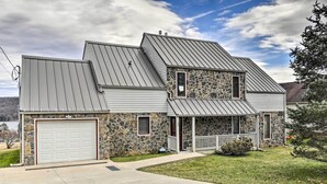 A two-story house with a stone facade, a garage, and a covered porch. - Alpine Lake Resort Home: Stunning Lake Views! (Terra Alta)
