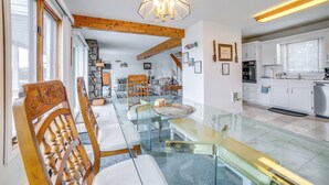 A modern kitchen with white cabinets, a built-in oven, and a large window with blinds. - Alpine Lake Resort Home: Stunning Lake Views! (Terra Alta)