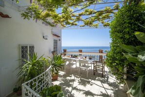 A terrace with a table set for dining, overlooking the sea. - Villa Arte- Luxurious Villa in Ravello (Minori)
