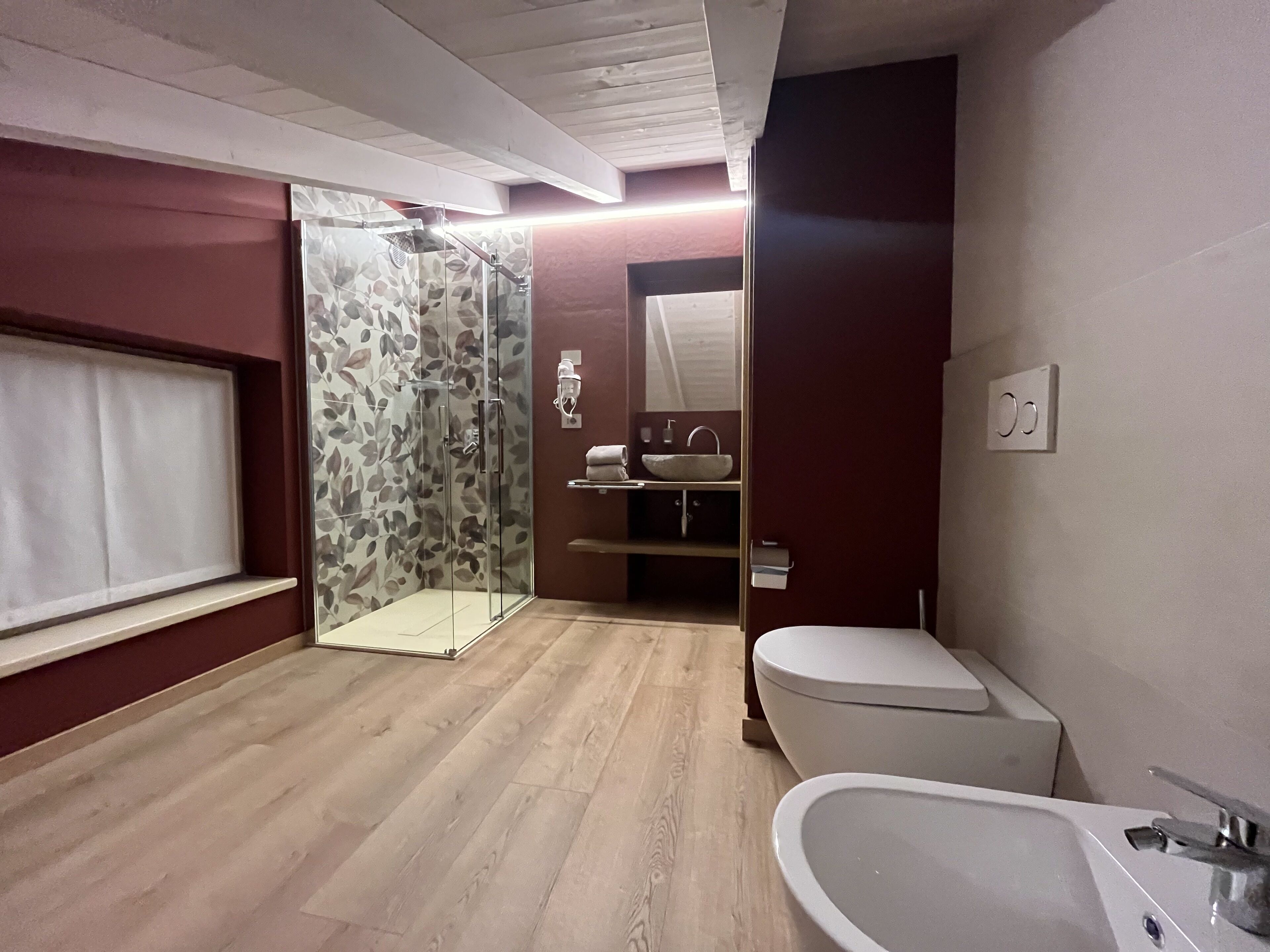 Uma casa de banho moderna com duche, sanita e banheira.