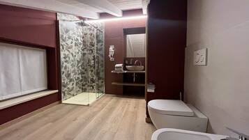 Uma casa de banho moderna com duche, sanita e banheira.