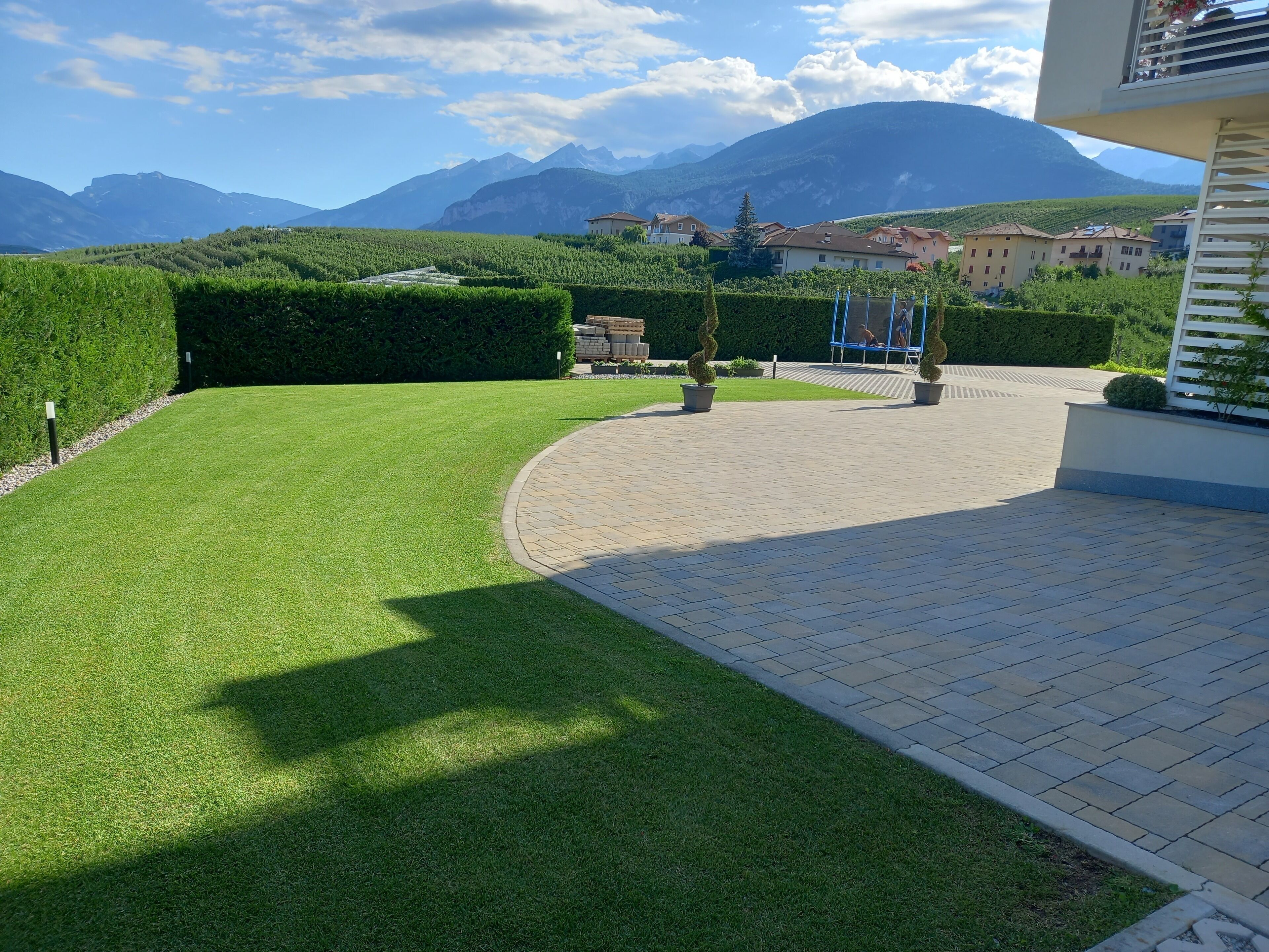 A well-maintained lawn with a paved walkway leading to a building.