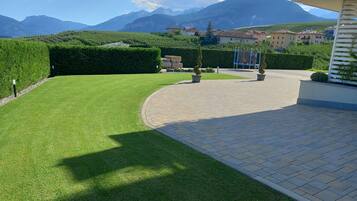 A well-maintained lawn with a paved walkway leading to a building.