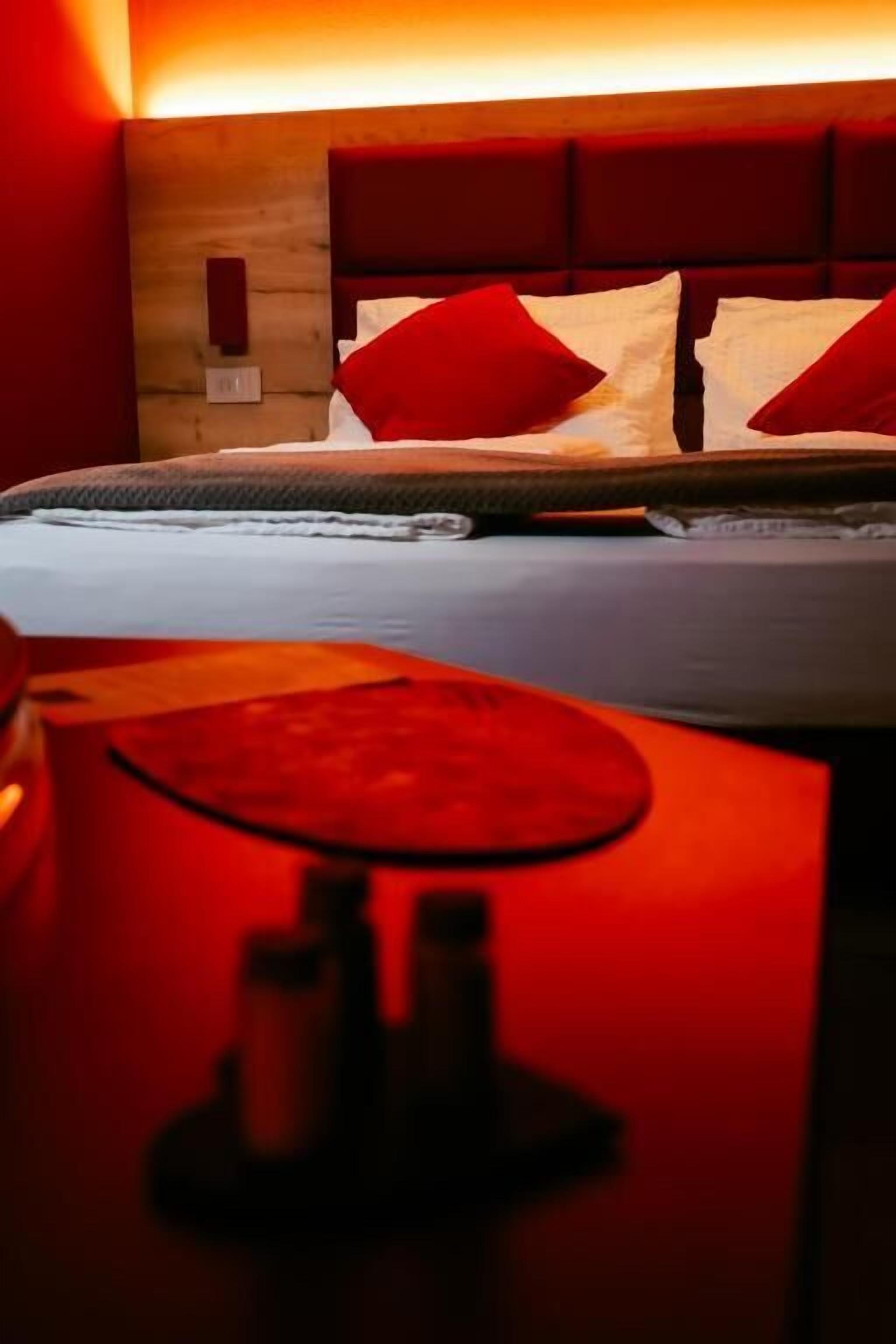 Un lit avec des oreillers rouges et une tête de lit en bois.