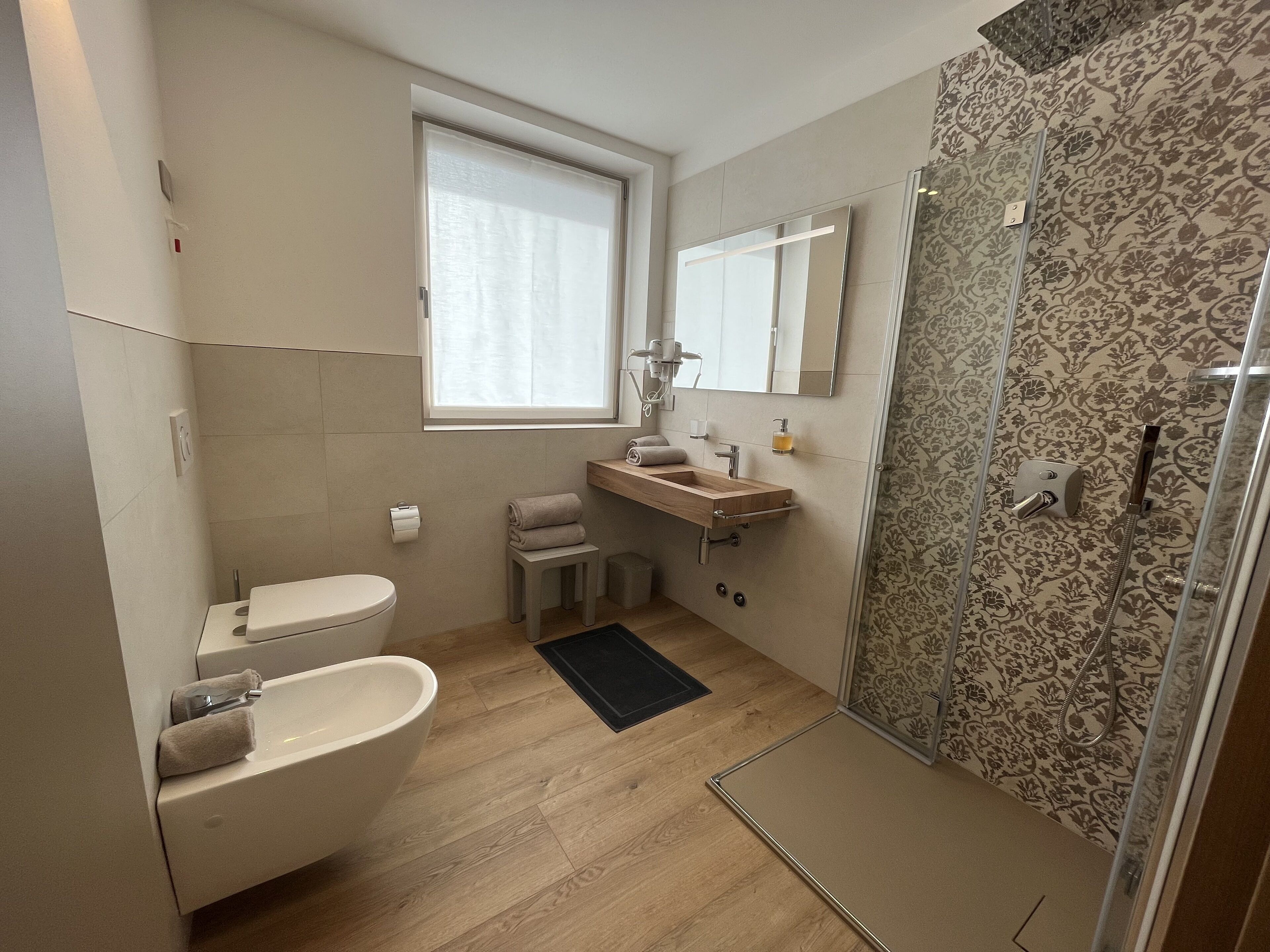 Une salle de bain moderne équipée de toilettes, d’un lavabo et d’une douche.