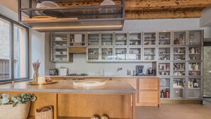 Een moderne keuken met houten kastjes, een centraal eiland en diverse keukengerei.
