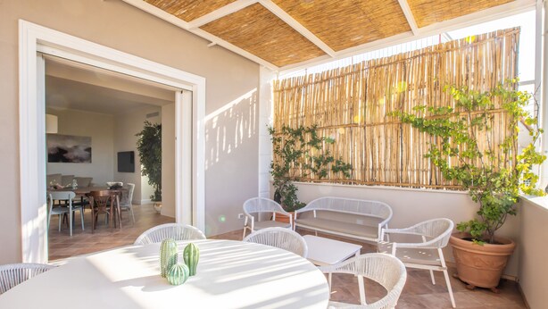 A patio with white wicker furniture, a table with a green object, and a potted plant. - COUNTRY LIFE RELAIS (Massa Lubrense)
