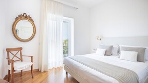 A bedroom with a bed, a chair, a mirror, and a window with curtains. - COUNTRY LIFE RELAIS (Massa Lubrense)