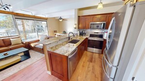 Una cocina moderna con una isla central, electrodomésticos de acero inoxidable y muebles de madera.