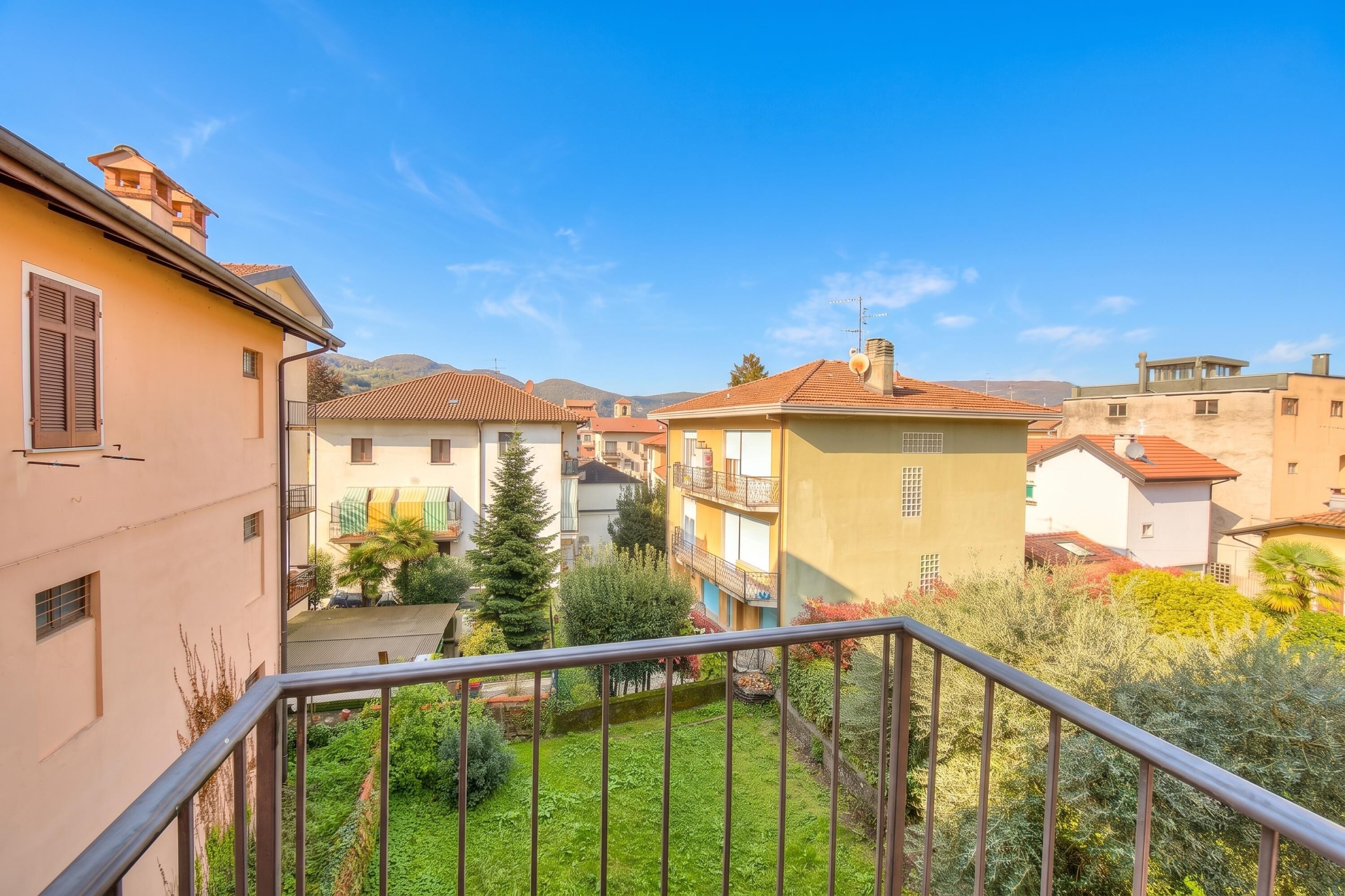 A residential area with buildings, a balcony, and a clear sky.