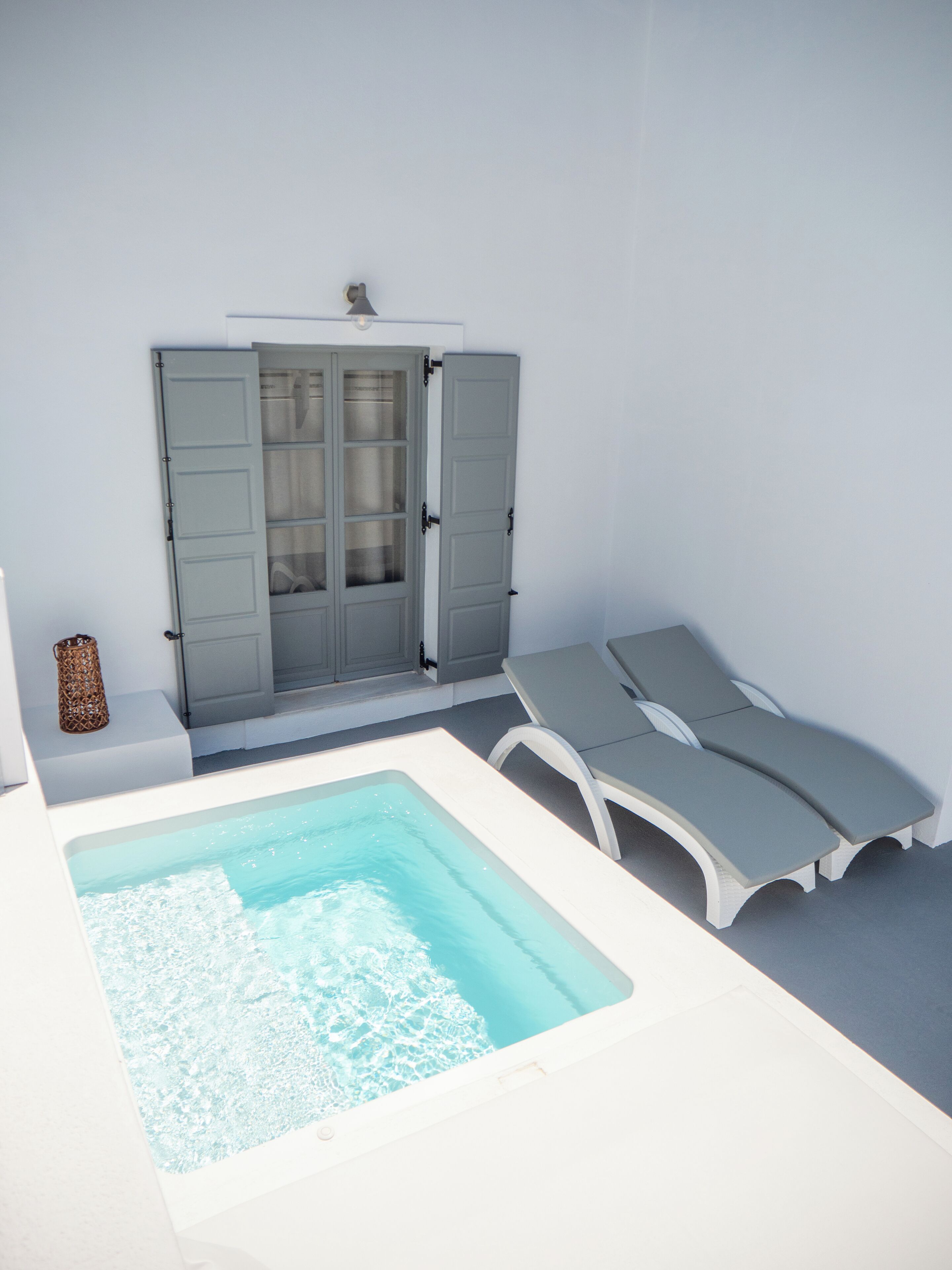 Un área de spa con un jacuzzi, dos sillones reclinables y un armario de vidrio.
