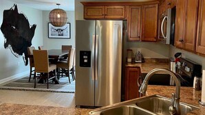 A kitchen with granite countertops, stainless steel appliances, wooden cabinets, and a pendant light. - Stylish Richmond Home. Near EKU and Downtown (Richmond)