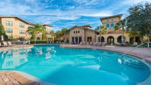 A swimming pool surrounded by buildings with a clear blue sky.