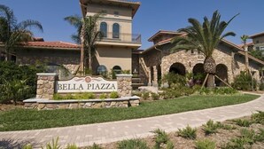 A sign for Bella Piazza with a stone facade and arched windows.