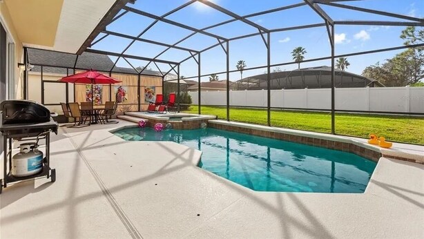A covered backyard with a swimming pool, patio furniture, and a grill. - Henley Haven 6 Bedroom Villa by RedAwning (Davenport)