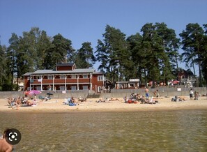 Una playa con un edificio al fondo.